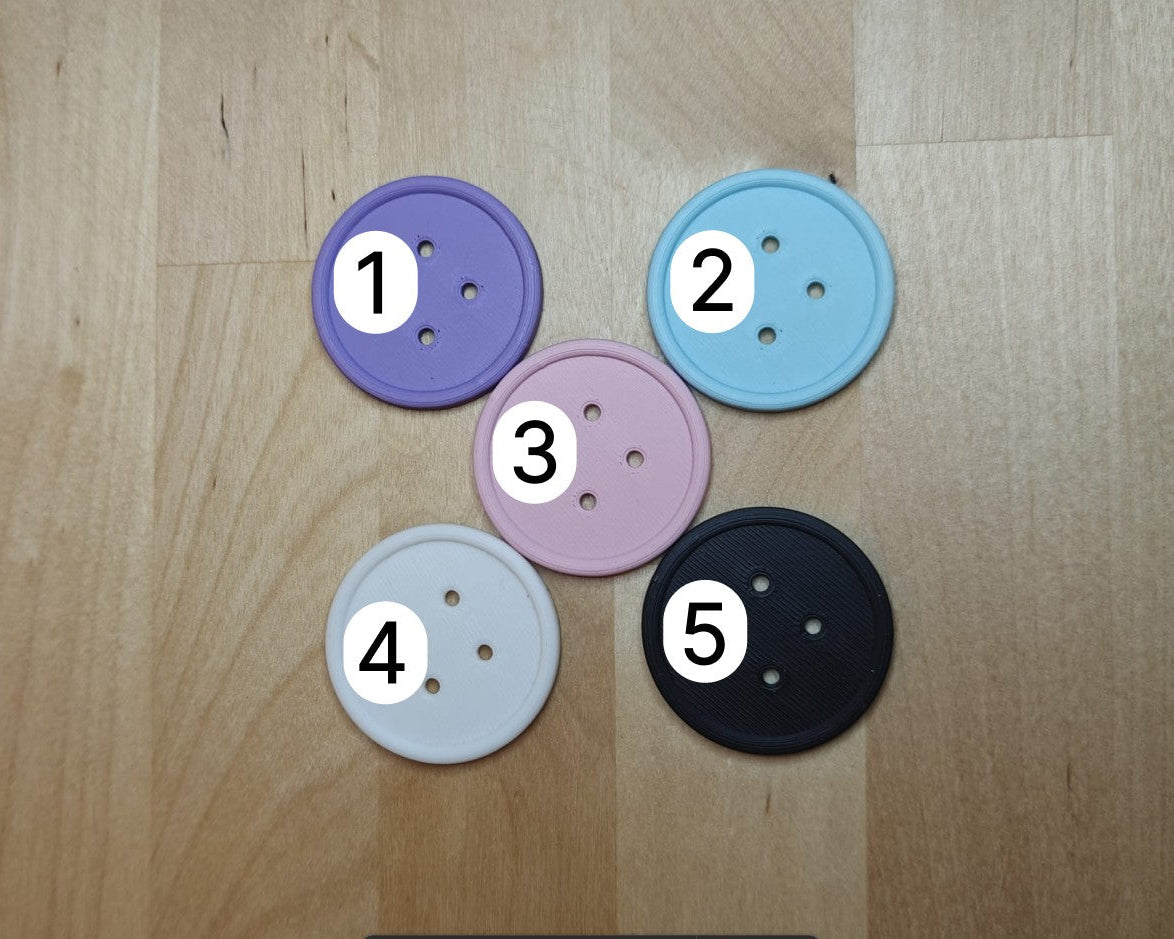 5 ge3Dprinte knopen om de verschillende kleuren weer te geven. De kleuren zijn lila, licht blauw, licht roze, wit en zwart